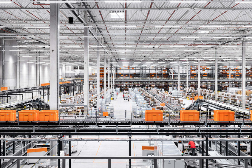 Interior of a Zalando fulfilment center, with orange crates on a conveyor system.
